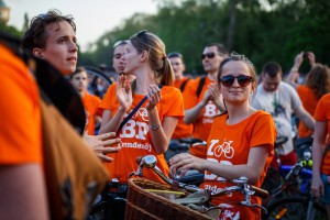 People on stationary bikes wearing orange shirts